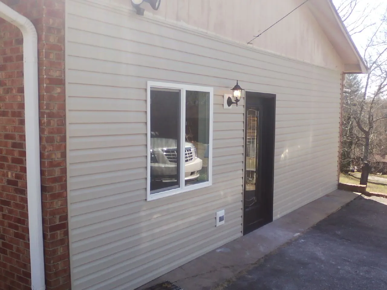 New vinyl siding and entry door on a room addition in Powellsville