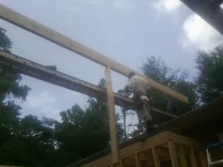Carpenter setting a ridge beam over a new addition frame — Ice Dam Removal by Roofing Brothers in Powellsville