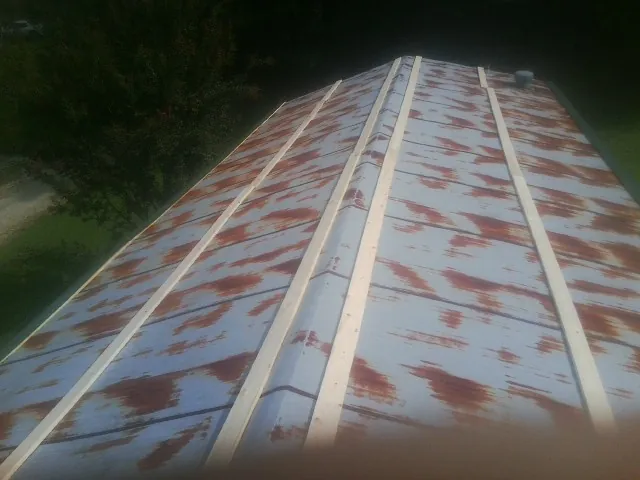 Rusted metal roof panels with new wood purlins before replacement — Storm Damage Roof Repair in Powellsville by Roofing Brothers